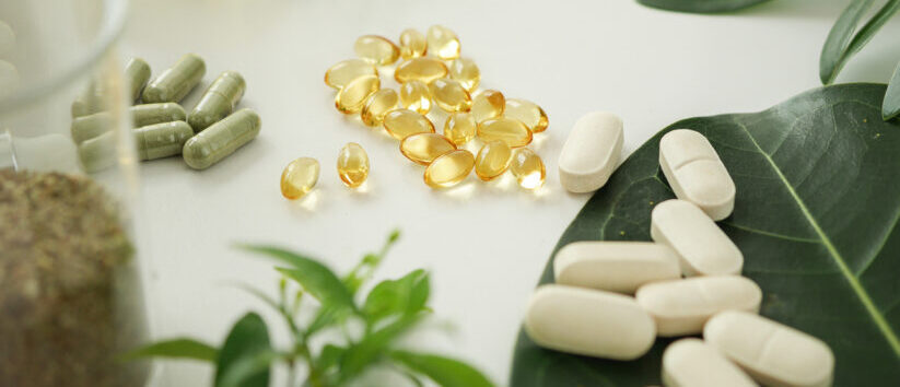 Pharmaceutical-grade supplements — softgels, capsules and tablets on natural foliage
